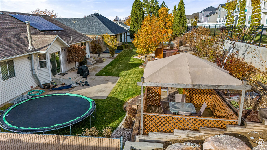 View of yard with a fenced backyard, a trampoline, a patio, and a residential view