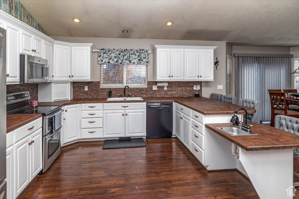 Kitchen with recessed lighting, a sink, a peninsula, and stainless steel appliances