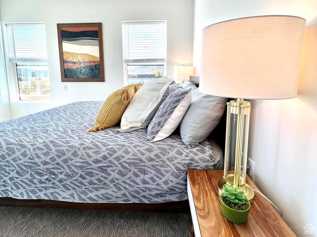 Carpeted bedroom with a textured ceiling and multiple windows