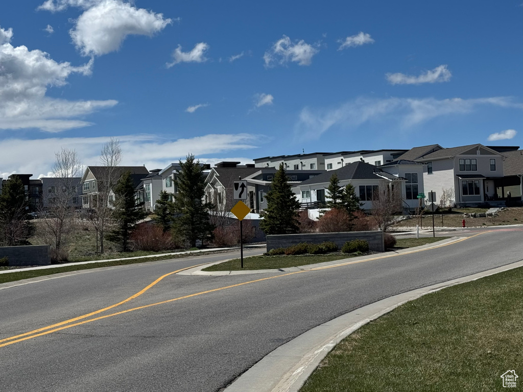 View of road featuring a residential view, sidewalks, traffic signs, and curbs
