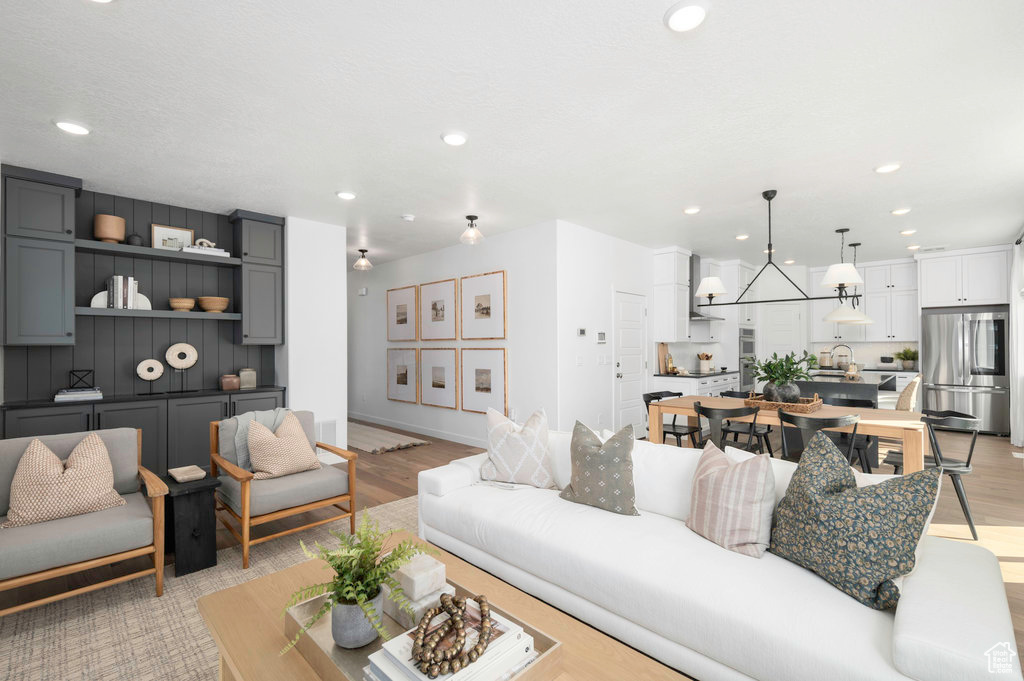 Living room with recessed lighting, baseboards, and light wood-style floors