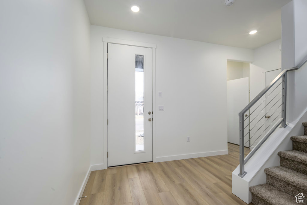 Entryway with light wood-type flooring, recessed lighting, stairs, and a wealth of natural light