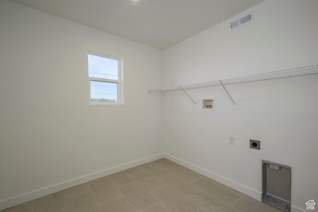 Clothes washing area featuring laundry area, electric dryer hookup, visible vents, baseboards, and hookup for a washing machine
