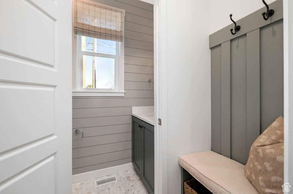 Mudroom featuring visible vents, wood walls, and baseboards