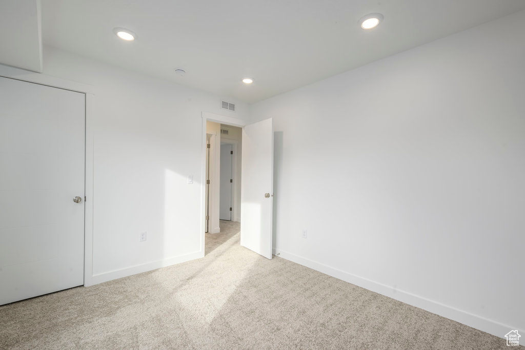 Unfurnished bedroom with carpet flooring, recessed lighting, baseboards, and visible vents