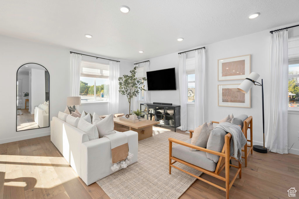 Living area featuring recessed lighting, a healthy amount of sunlight, and hardwood / wood-style flooring