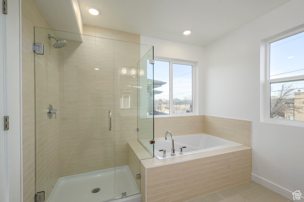 Bathroom featuring tile patterned floors, a shower stall, a healthy amount of sunlight, and a garden tub