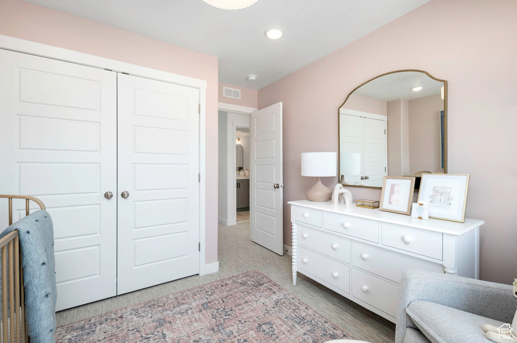 Bedroom with light colored carpet, arched walkways, visible vents, and recessed lighting