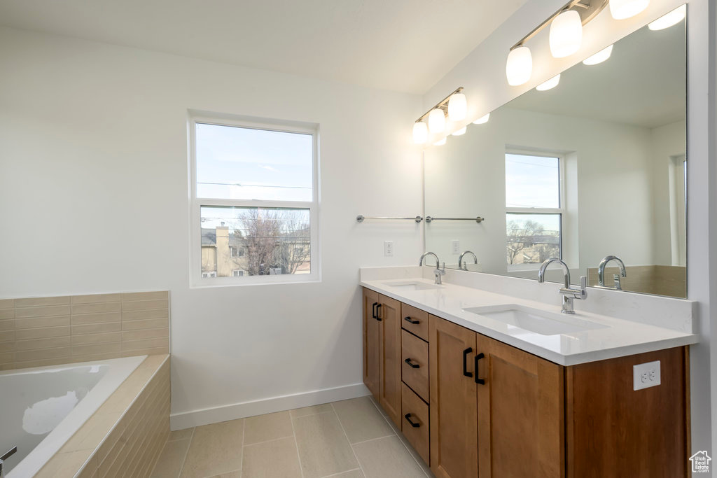Full bath with double vanity, baseboards, a sink, and tile patterned flooring