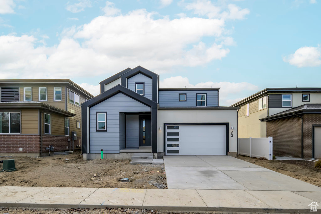 View of front facade with fence and driveway