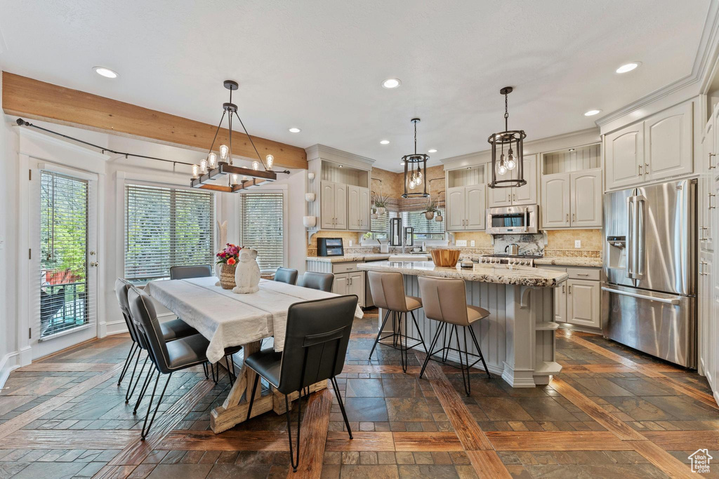 Dining area featuring an inviting chandelier, baseboards, and recessed lighting