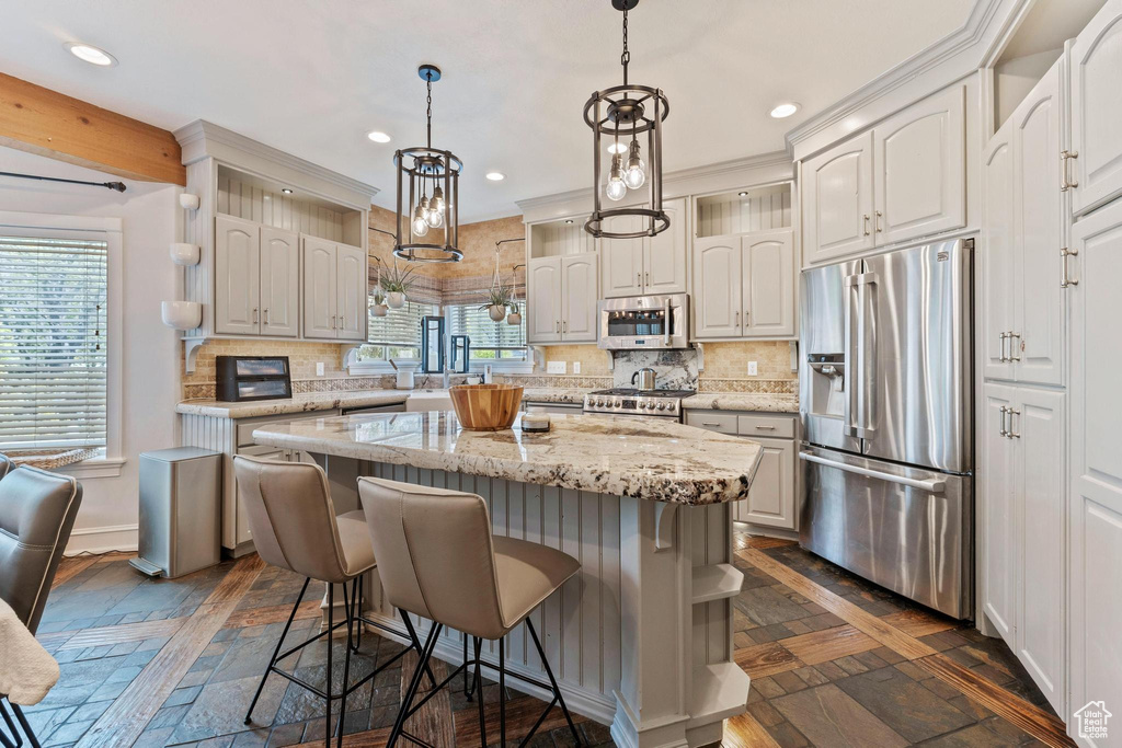 Kitchen with recessed lighting, a breakfast bar area, a kitchen island, and stainless steel appliances