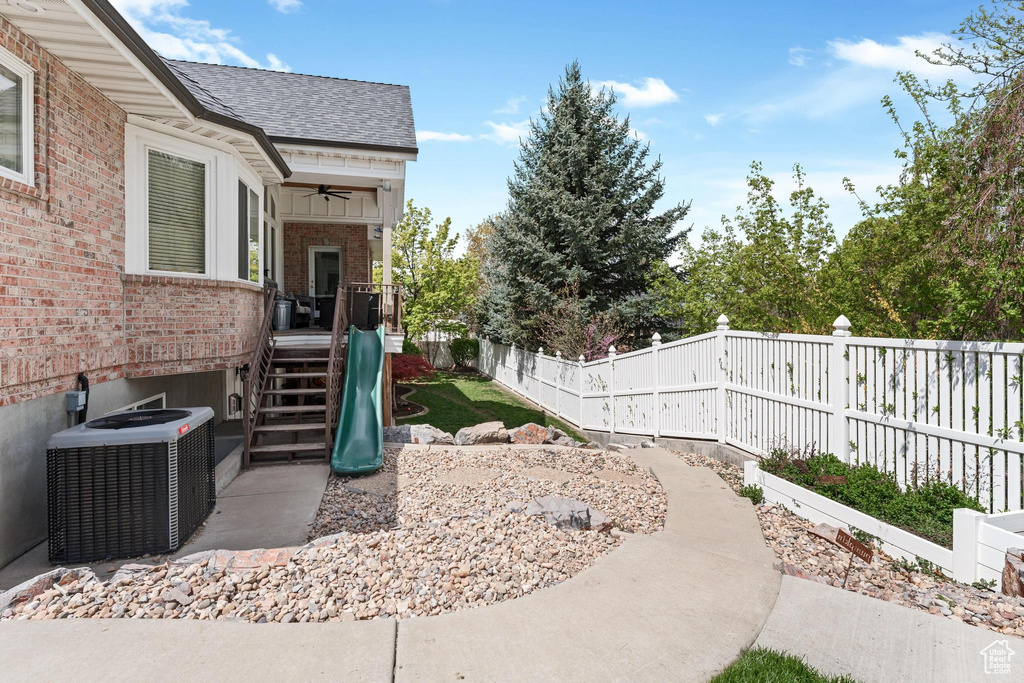 View of yard featuring central AC, a ceiling fan, and a fenced backyard