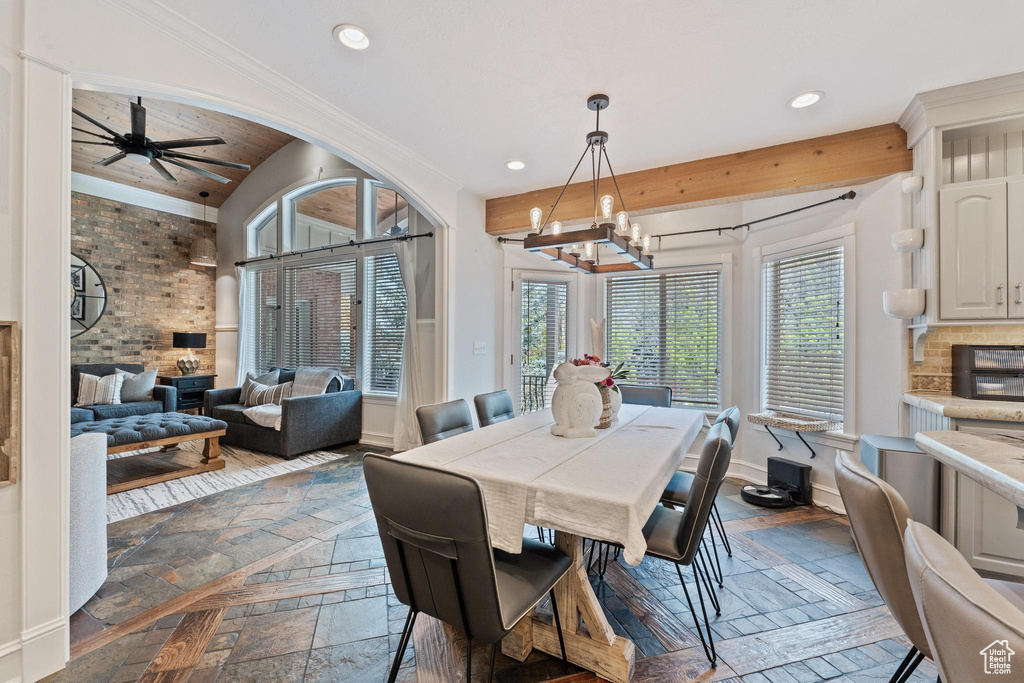 Dining area with baseboards, recessed lighting, ceiling fan with notable chandelier, and stone tile floors