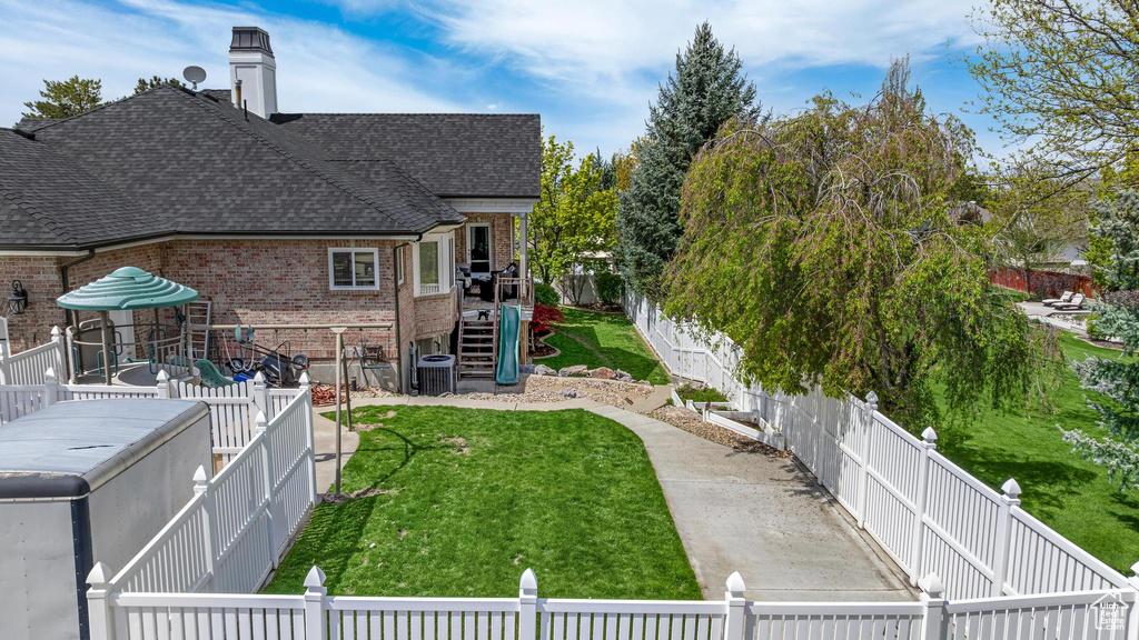 View of yard featuring stairway, central AC unit, and a fenced backyard