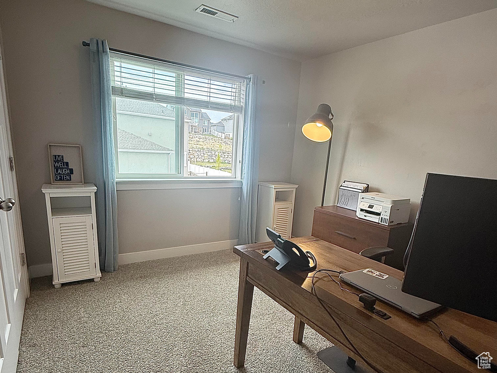 Office area with carpet floors, baseboards, a textured ceiling, and visible vents