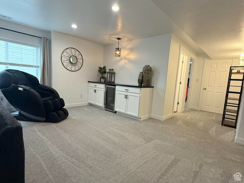 Living area with baseboards, carpet flooring, recessed lighting, and beverage cooler