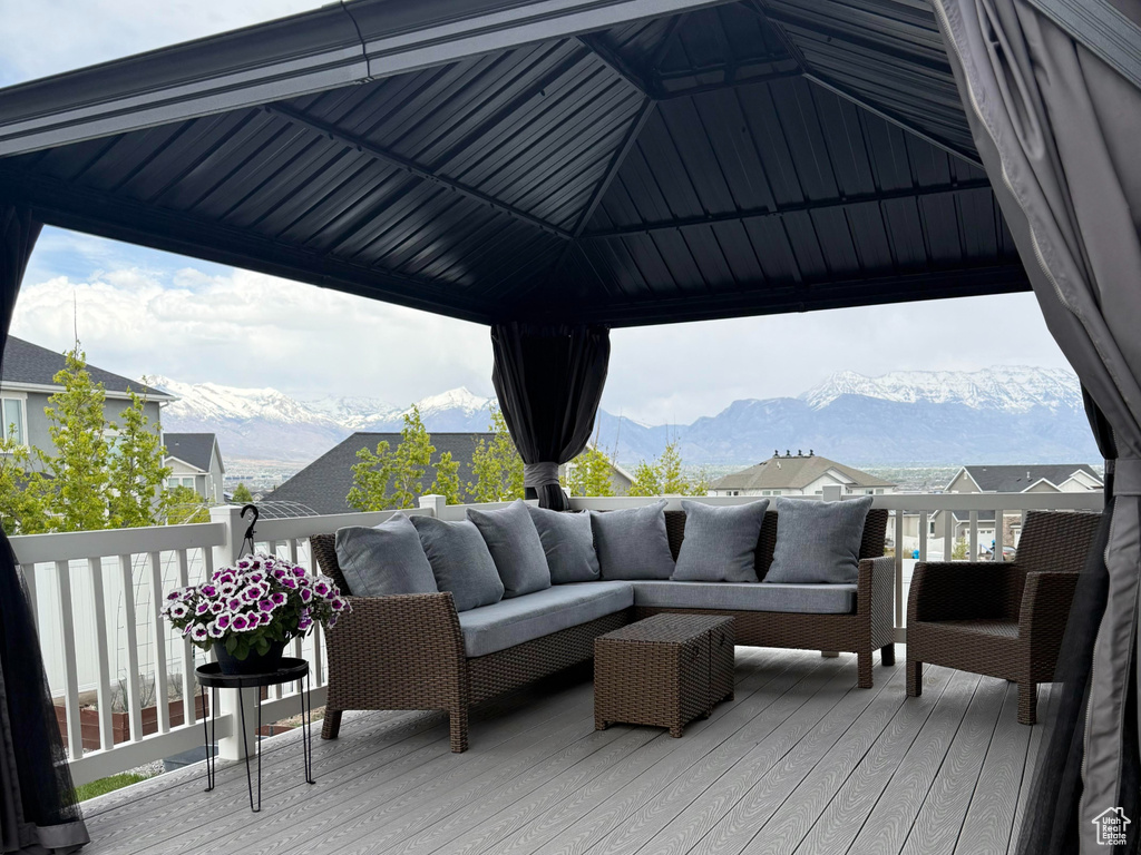 Wooden deck with an outdoor hangout area, a mountain view, and a gazebo