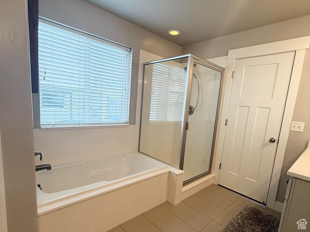 Full bath with tile patterned floors, a shower stall, a garden tub, and vanity
