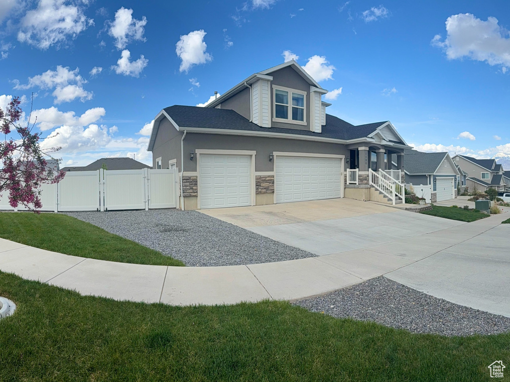 View of property exterior featuring a residential view, fence, an attached garage, a gate, and concrete driveway