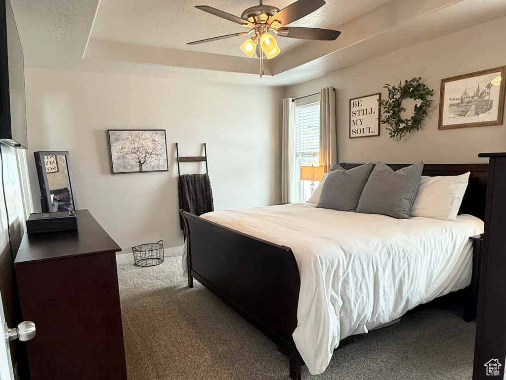 Bedroom with carpet flooring, a ceiling fan, and a textured ceiling
