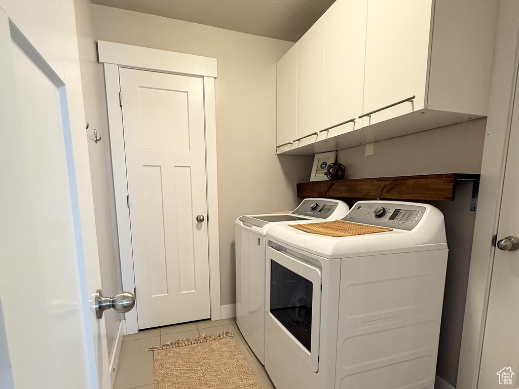 Washroom featuring a textured ceiling, visible vents, cabinet space, separate washer and dryer, and light tile patterned flooring