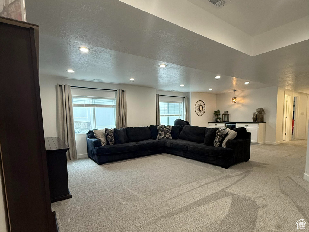 Living room with recessed lighting, light colored carpet, a wealth of natural light, and visible vents