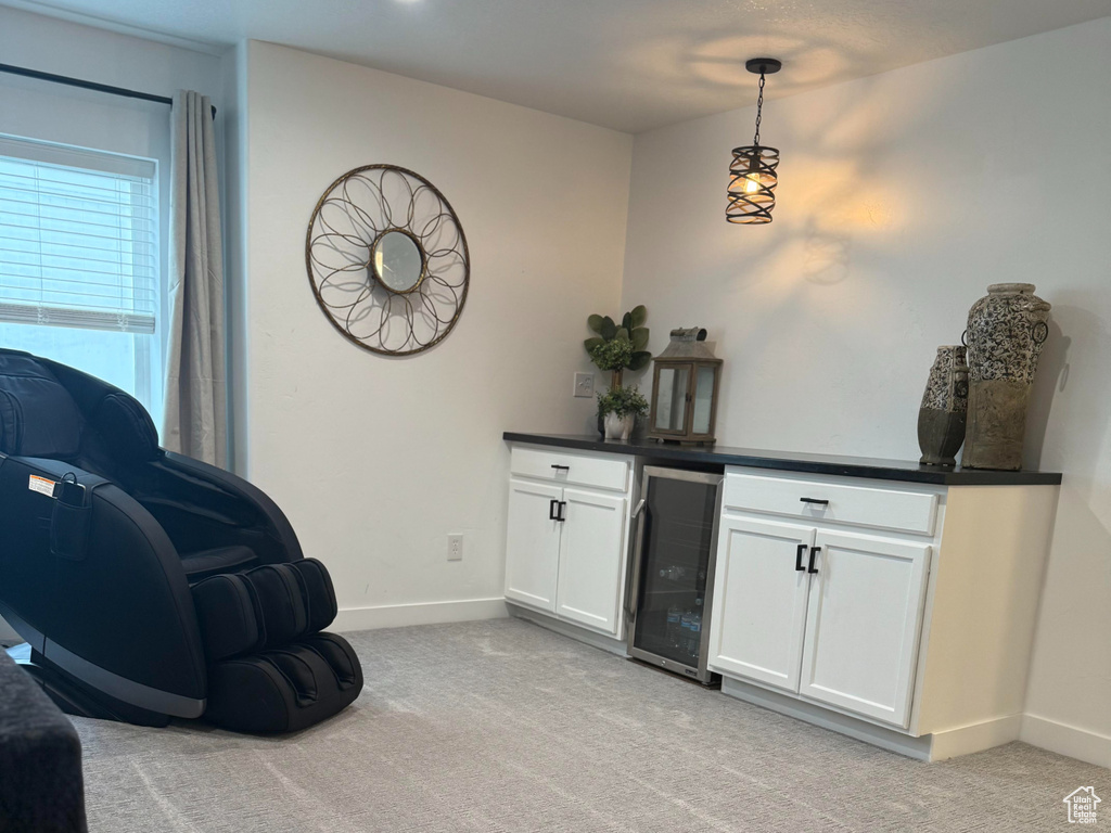Interior space featuring baseboards, light colored carpet, and wine cooler