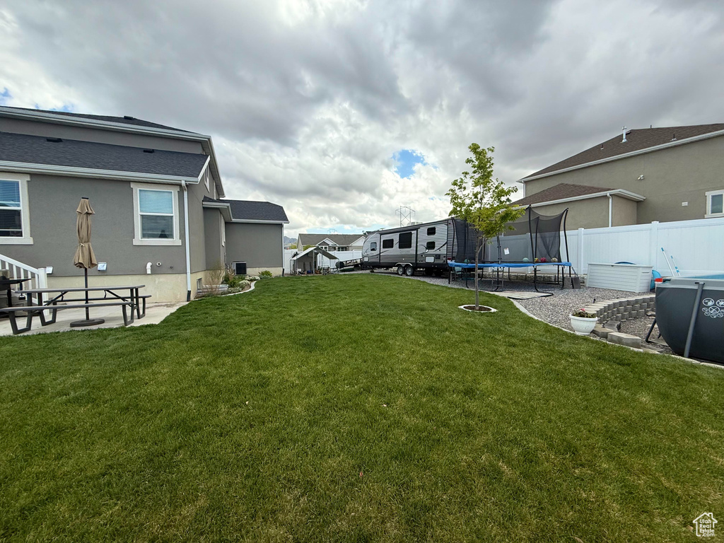 View of yard featuring a trampoline and fence