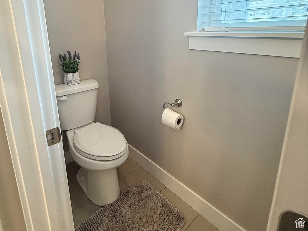 Bathroom with baseboards, tile patterned floors, and toilet