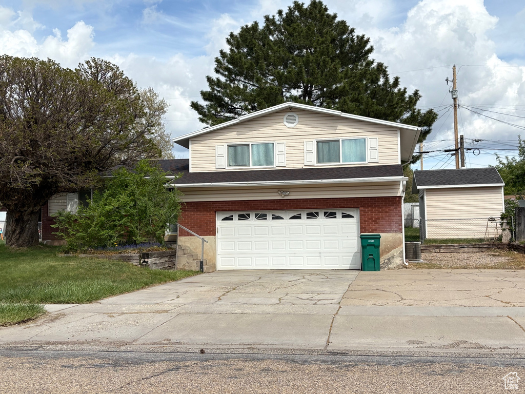 View of front of property featuring concrete driveway, brick siding, and an attached garage