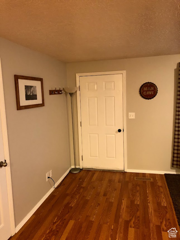 Interior space with baseboards, visible vents, and dark wood-type flooring