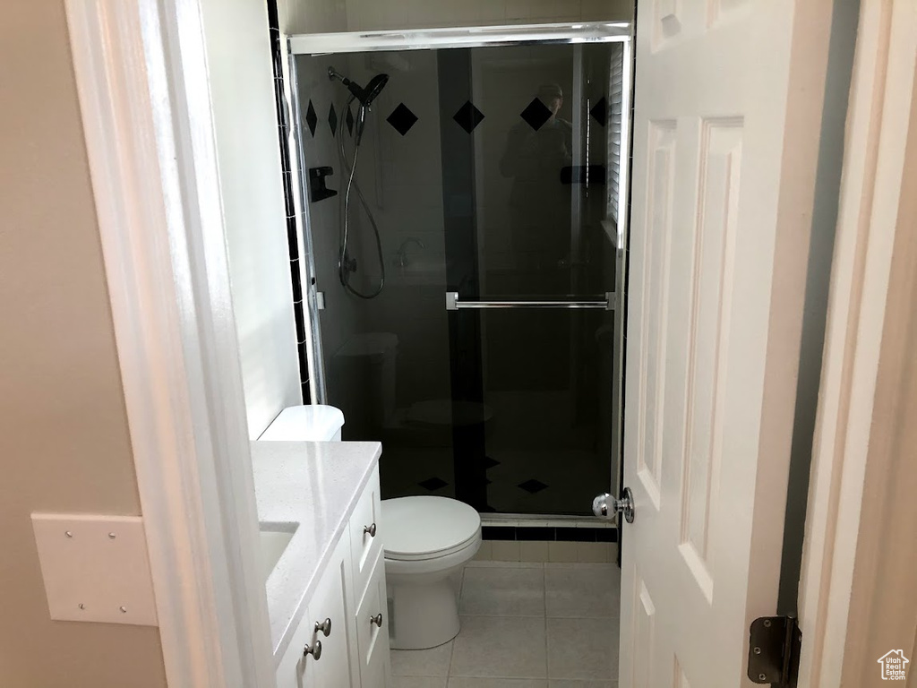 Bathroom with tile patterned flooring, a shower stall, toilet, and vanity