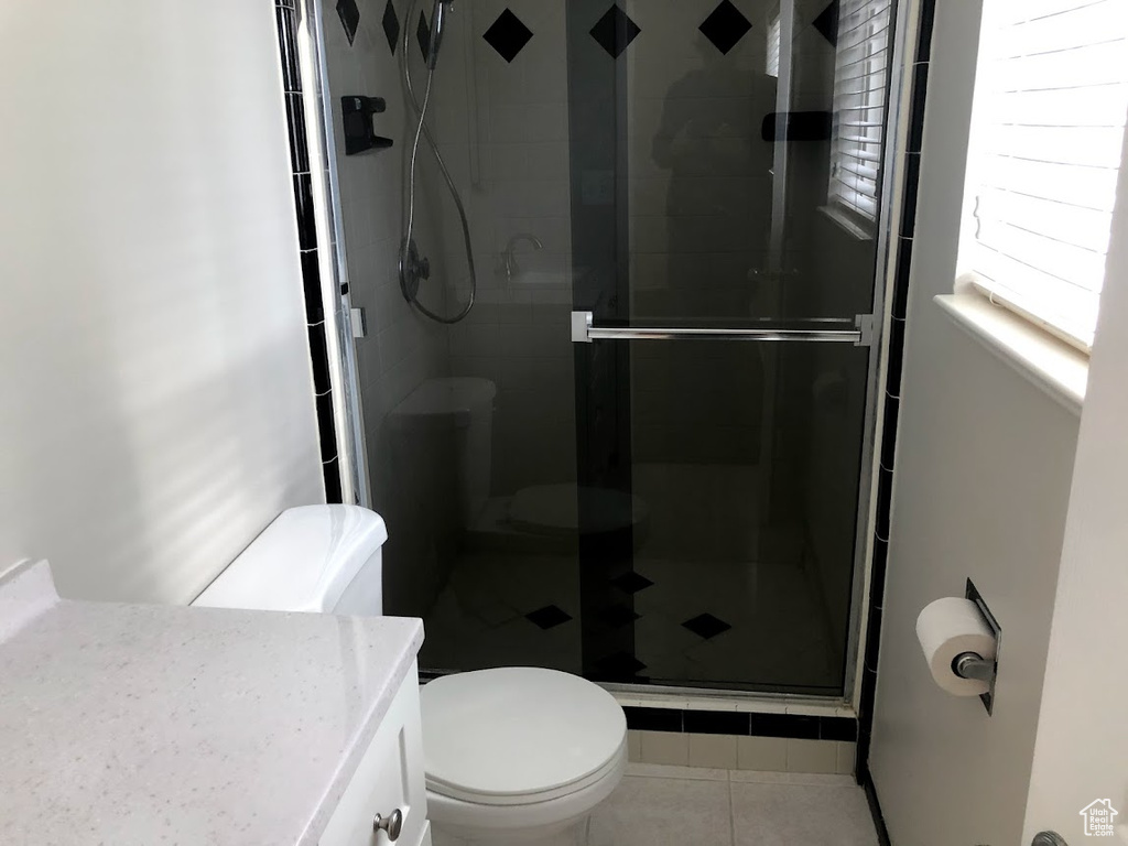 Full bathroom with vanity, tile patterned flooring, a shower stall, and toilet