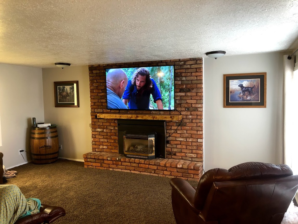 Carpeted living room featuring baseboards, a brick fireplace, and a textured ceiling