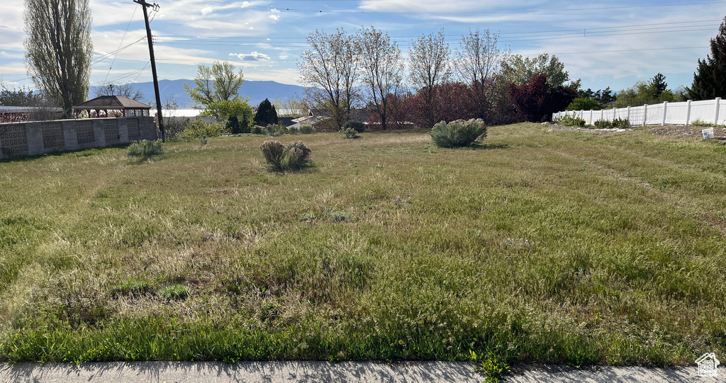 View of yard with fence and a mountain view