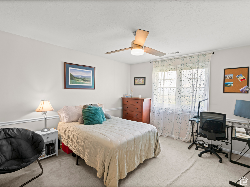 Carpeted bedroom featuring visible vents and ceiling fan