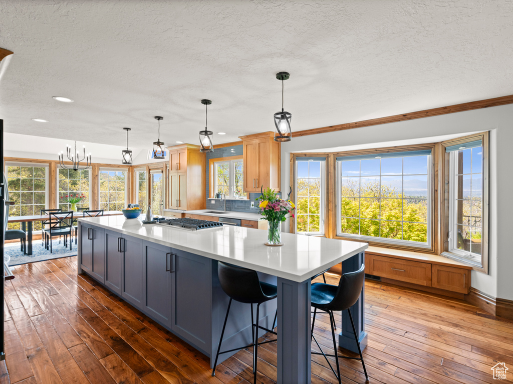 Kitchen with light countertops, hardwood / wood-style flooring, and a textured ceiling