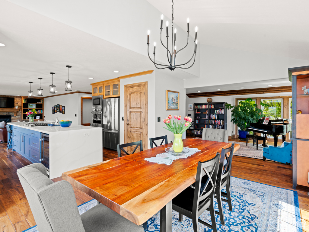 Dining space with recessed lighting, a chandelier, dark wood-type flooring, and wine cooler