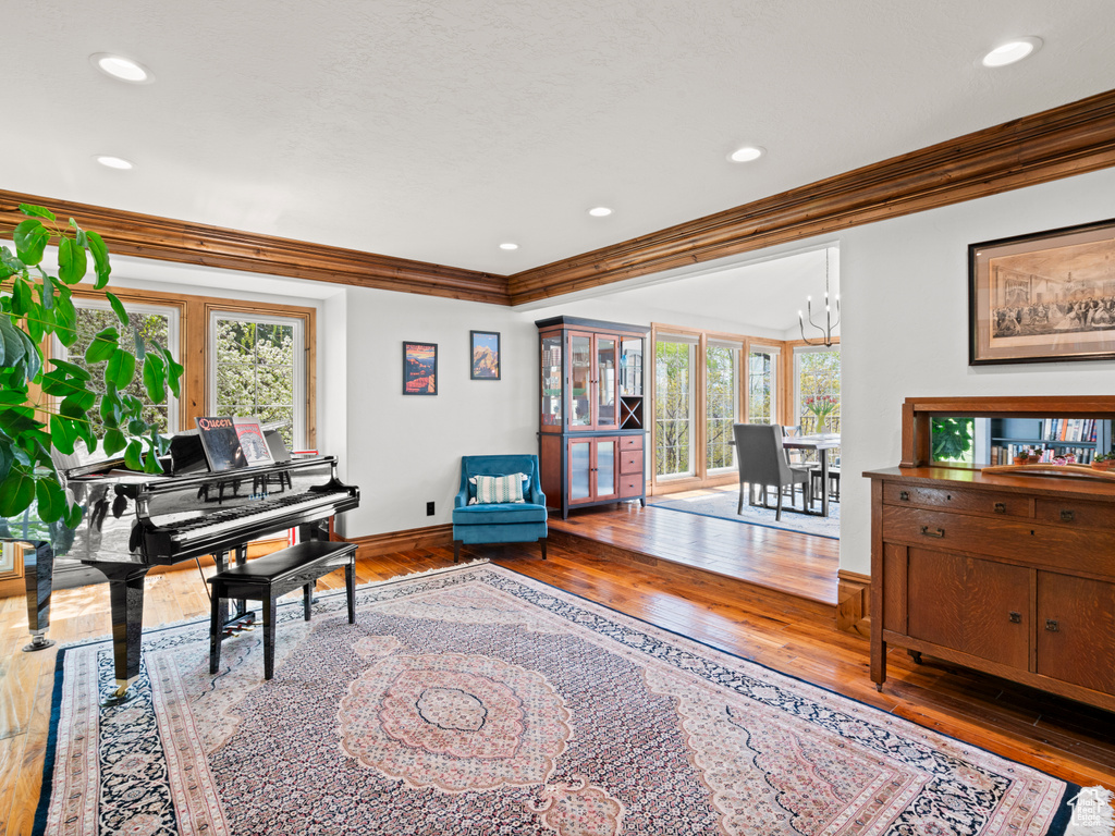 Interior space featuring ornamental molding, a notable chandelier, hardwood / wood-style flooring, and a wealth of natural light