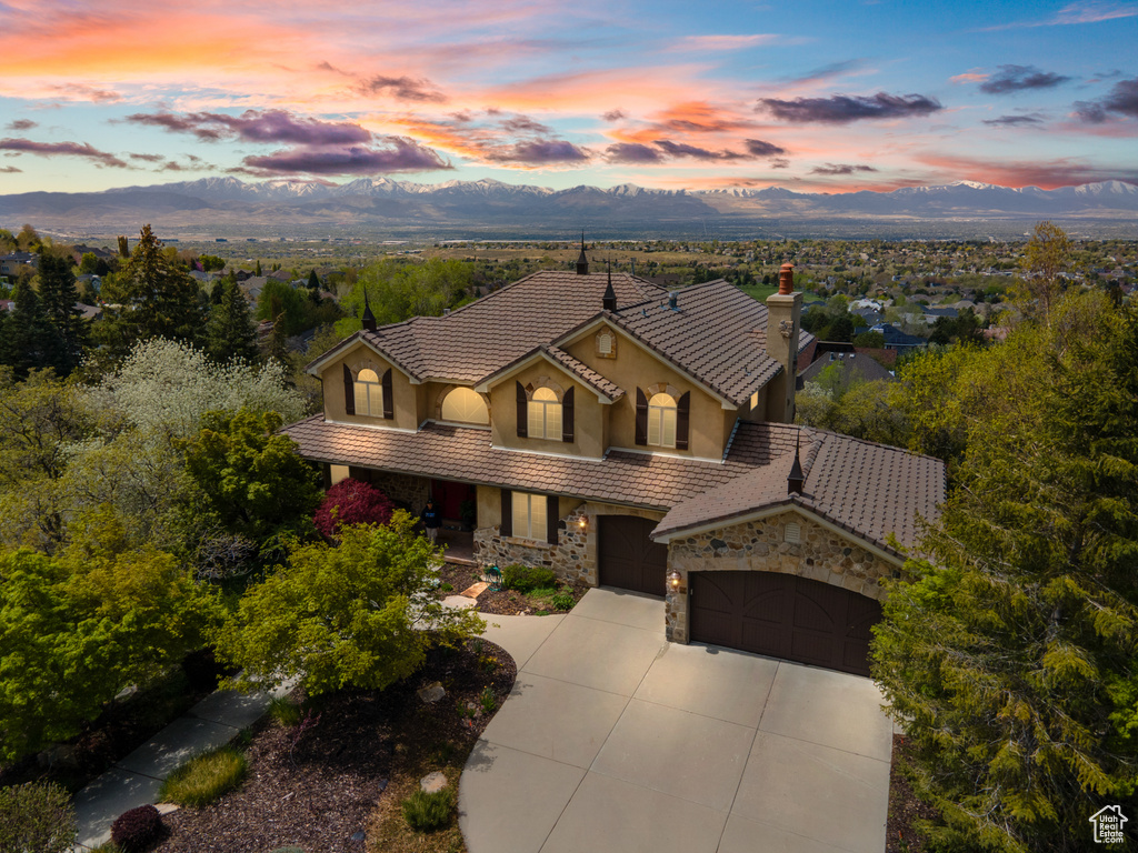 Mediterranean / spanish house featuring driveway, a mountain view, a tile roof, and stucco siding