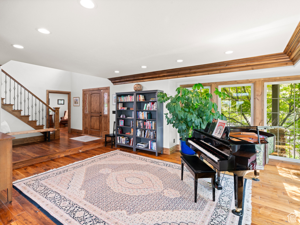 Living area featuring baseboards, wood-type flooring, and stairs