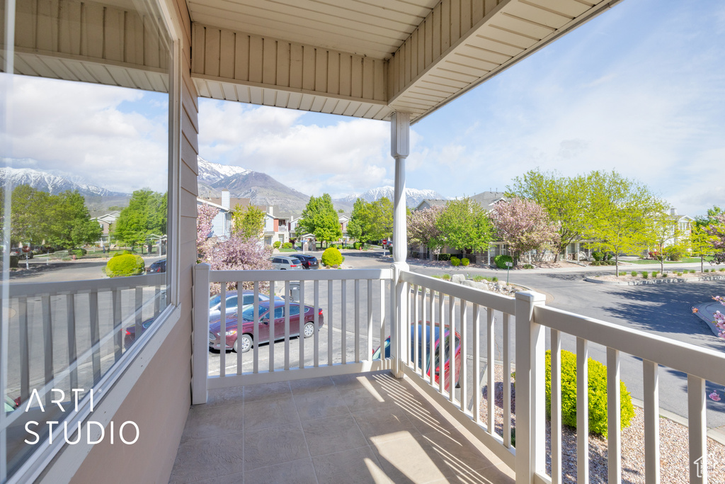 Balcony featuring a porch, a residential view, and a mountain view