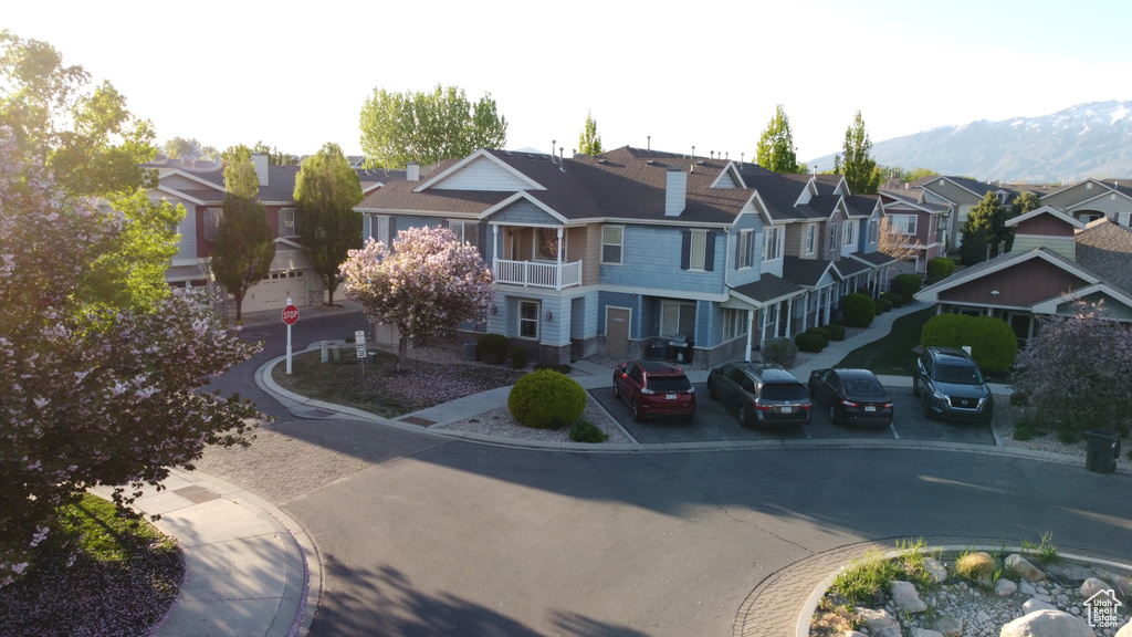View of road with curbs, a residential view, a mountain view, sidewalks, and traffic signs