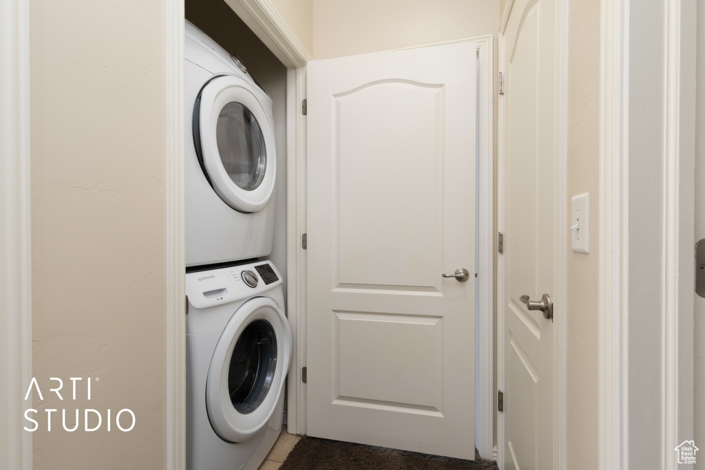Clothes washing area with stacked washer and dryer and laundry area