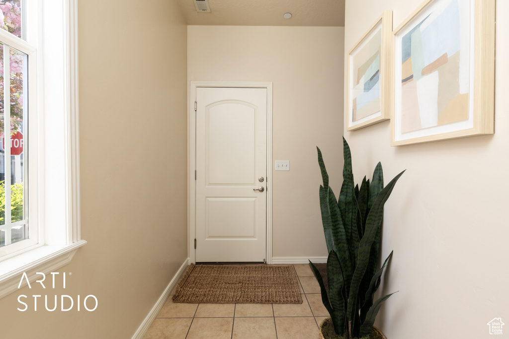 Doorway featuring baseboards and light tile patterned floors
