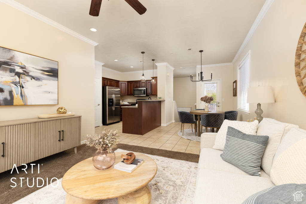 Living room featuring ornamental molding, baseboards, recessed lighting, ceiling fan with notable chandelier, and light tile patterned floors