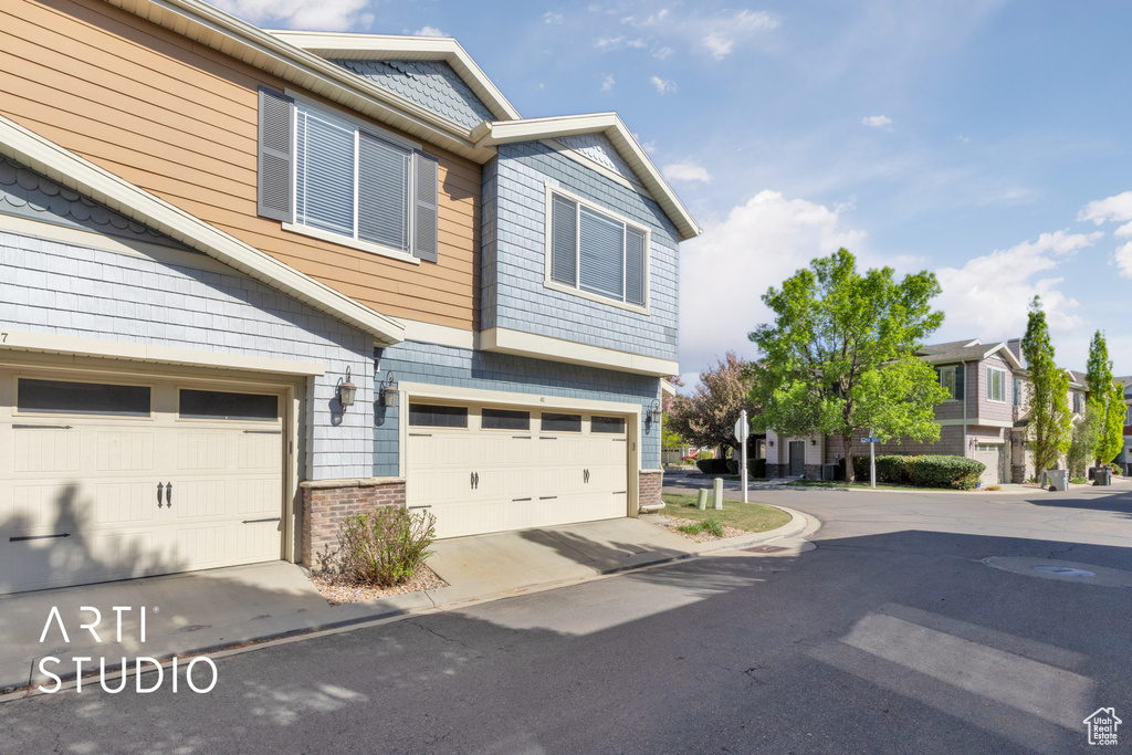 View of front of home featuring an attached garage and brick siding