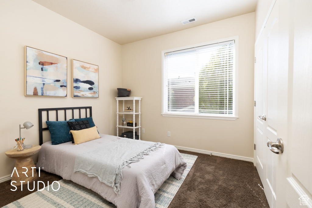 Bedroom with carpet flooring, baseboards, and visible vents