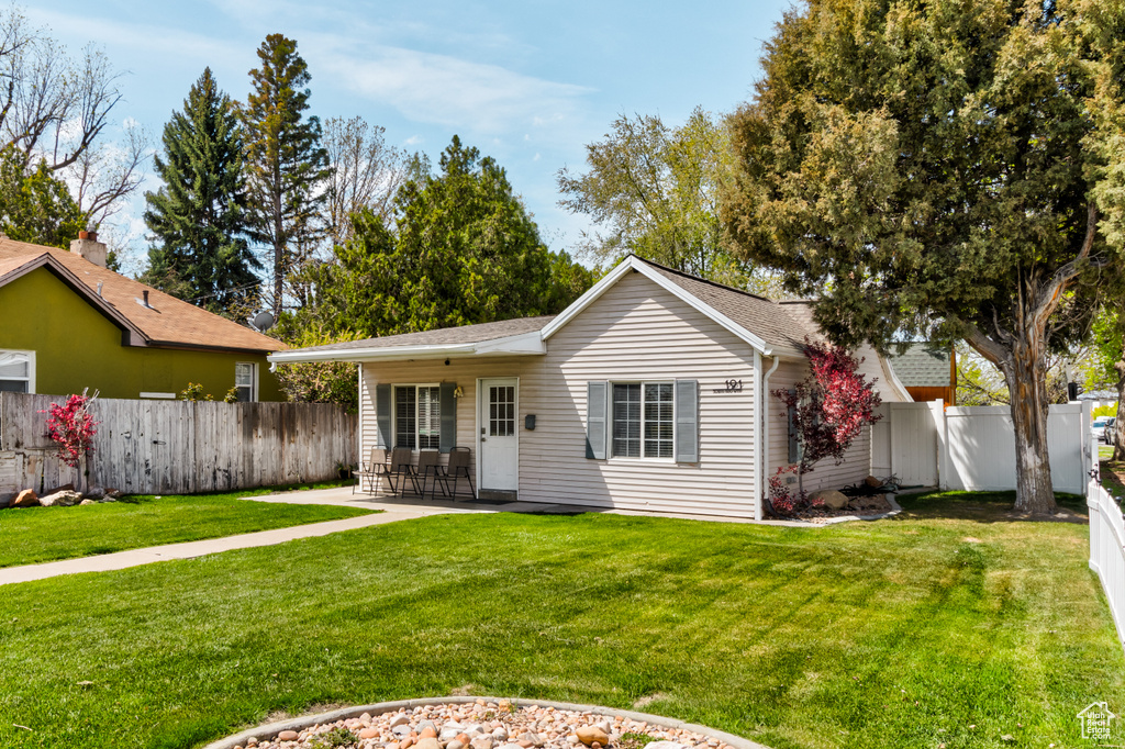 Rear view of property featuring a patio, a fenced backyard, a yard, and a shingled roof